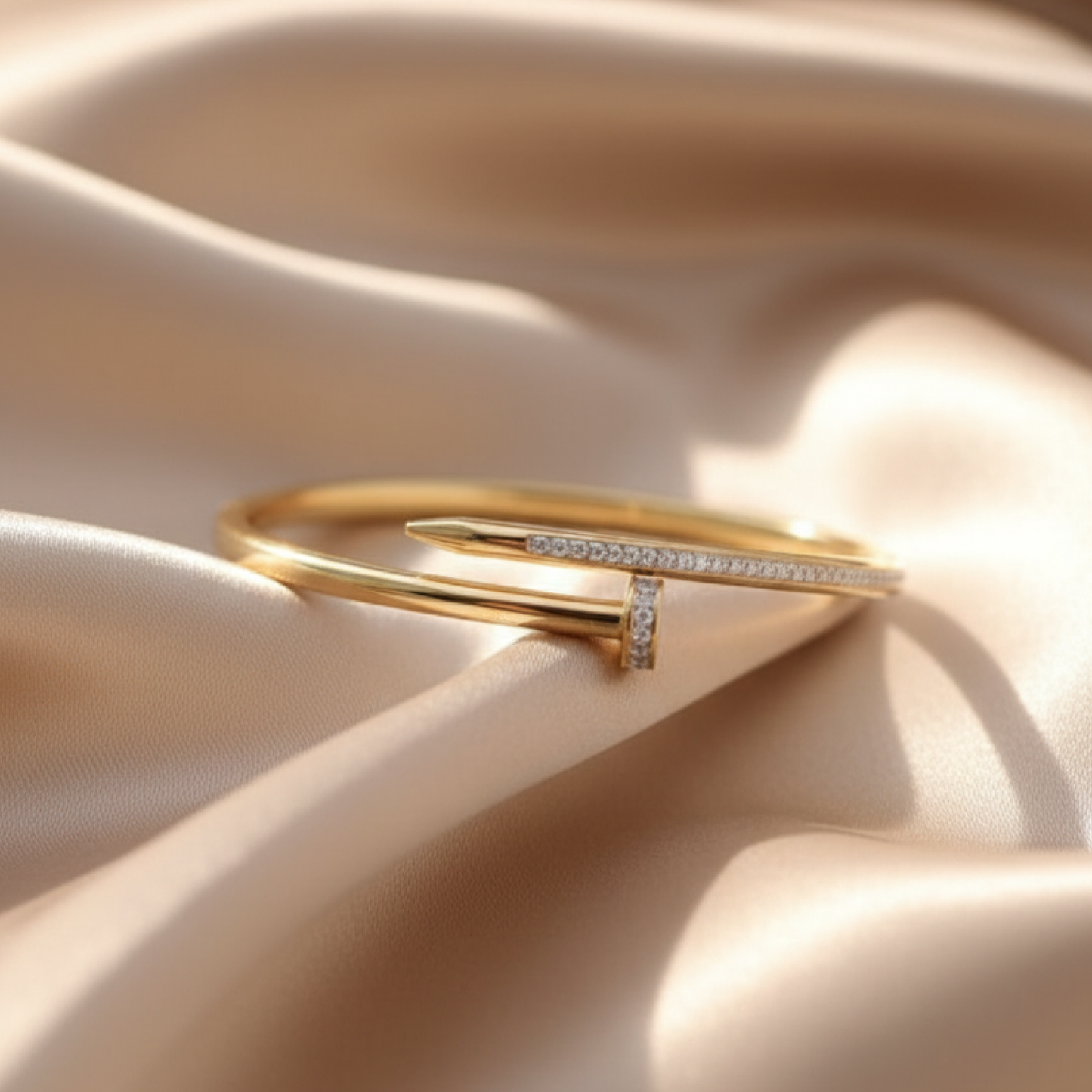 Gold nail design bracelet with diamond accents on beige satin fabric