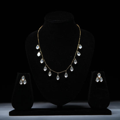 Classic teardrop Polki diamond necklace set with matching earrings displayed on black stand