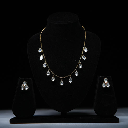 Classic teardrop Polki diamond necklace set with matching earrings displayed on black stand