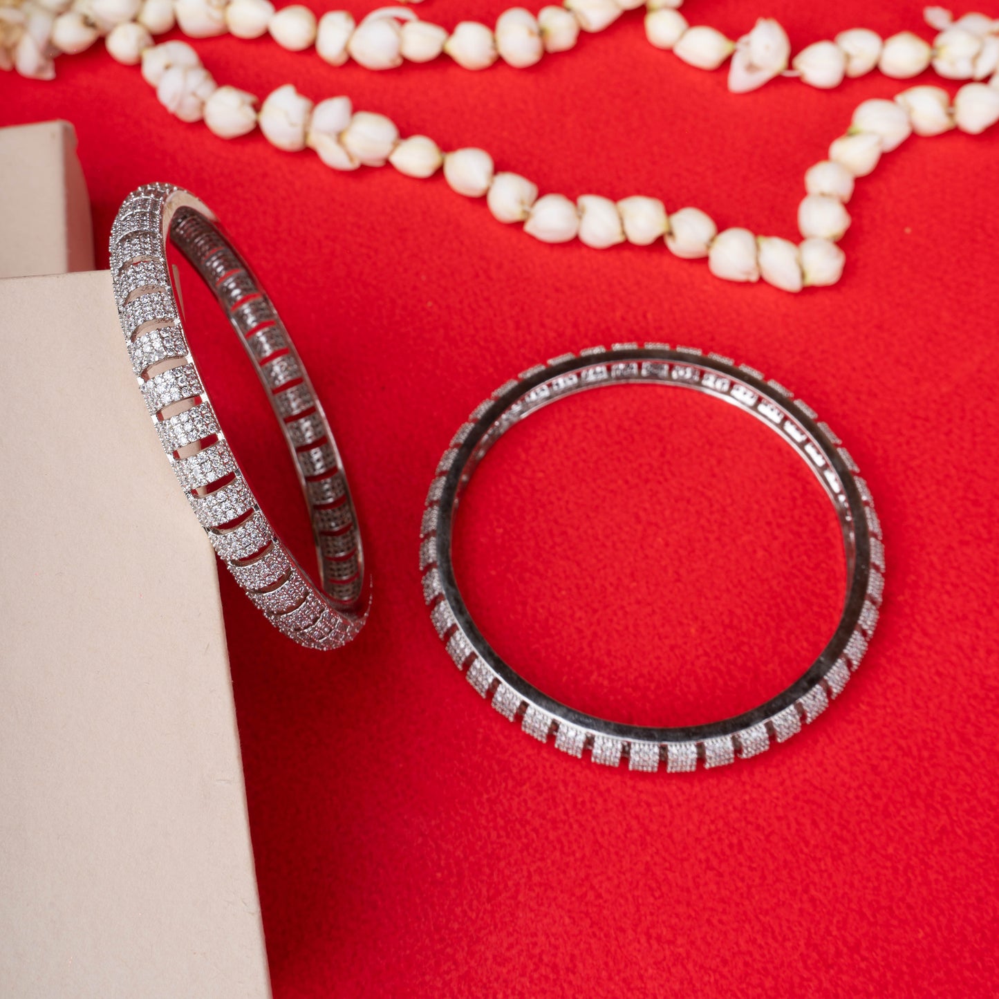 Silver striped zircon bangles with horizontal stone pattern on red background - Revaaj