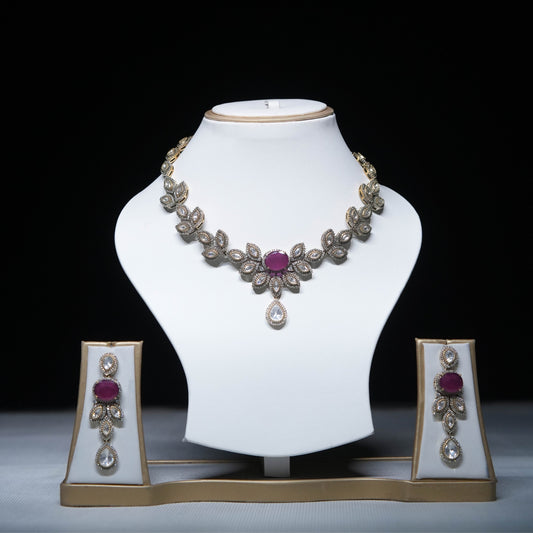 Royal ruby floral necklace set with matching earrings displayed on white stand