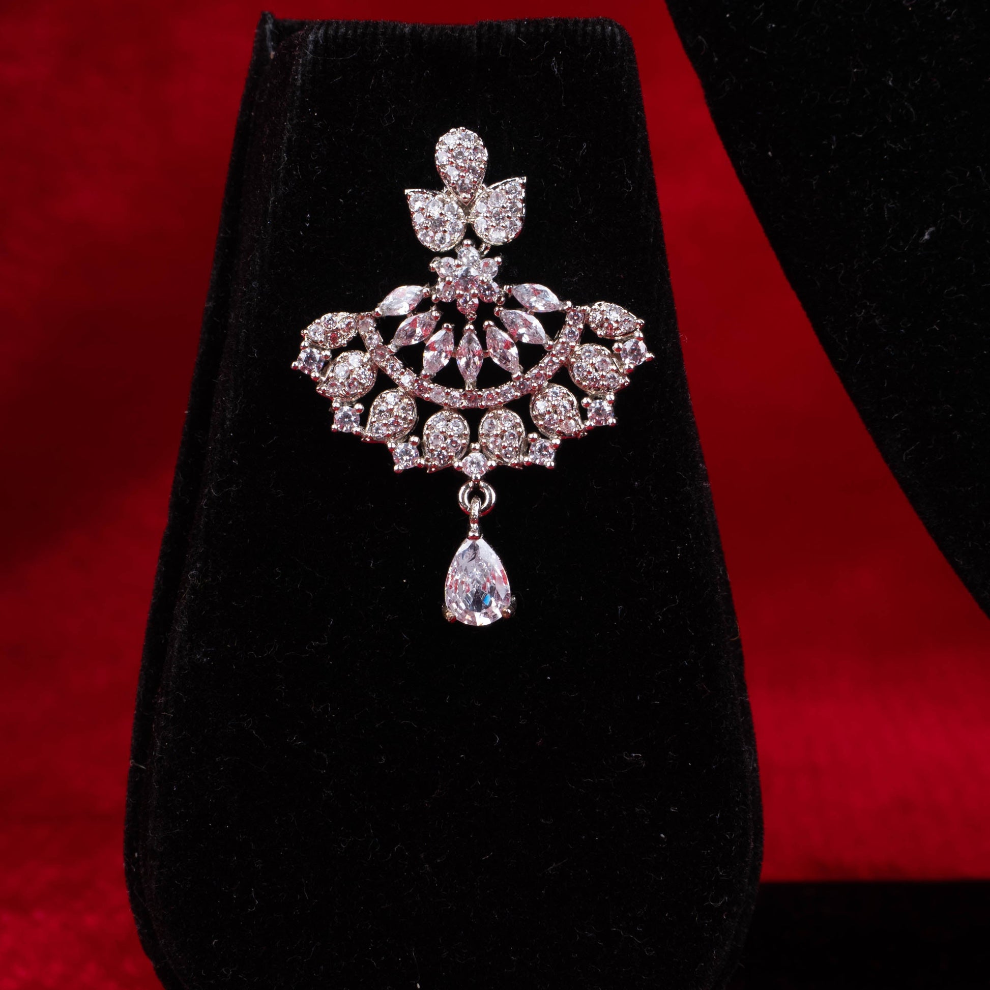 Silver-tone fan design necklace and earrings set with clear synthetic stones on red background - Revaaj Ground