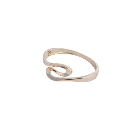 Gold-tone open cuff bracelet with a sculptural, looping design on a black mannequin hand white background - Revaaj