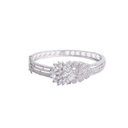 Ornate silver-tone hinged bracelet with a large, sparkling floral cluster made of clear crystals, and a band decorated with three rows of crystals and heart-shaped cutouts white image - Revaaj