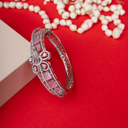 Silver-tone hinged bracelet with a row of pale pink gemstones, a central crystal-encrusted bow, and a crystal-paved band ground image - Revaaj