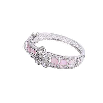 Silver-tone hinged bracelet with a row of pale pink gemstones, a central crystal-encrusted bow, and a crystal-paved band white image - Revaaj