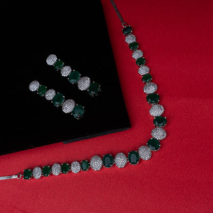 Necklace and earring set with alternating green oval stones and clear crystal-studded links on red background
