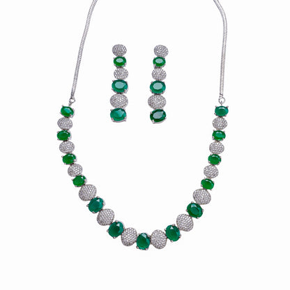 Necklace and earring set with alternating green stones and clear crystal-studded round links on white background