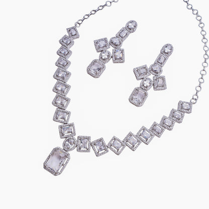 Necklace and earring set with square and oval clear stones in halo setting on white background
