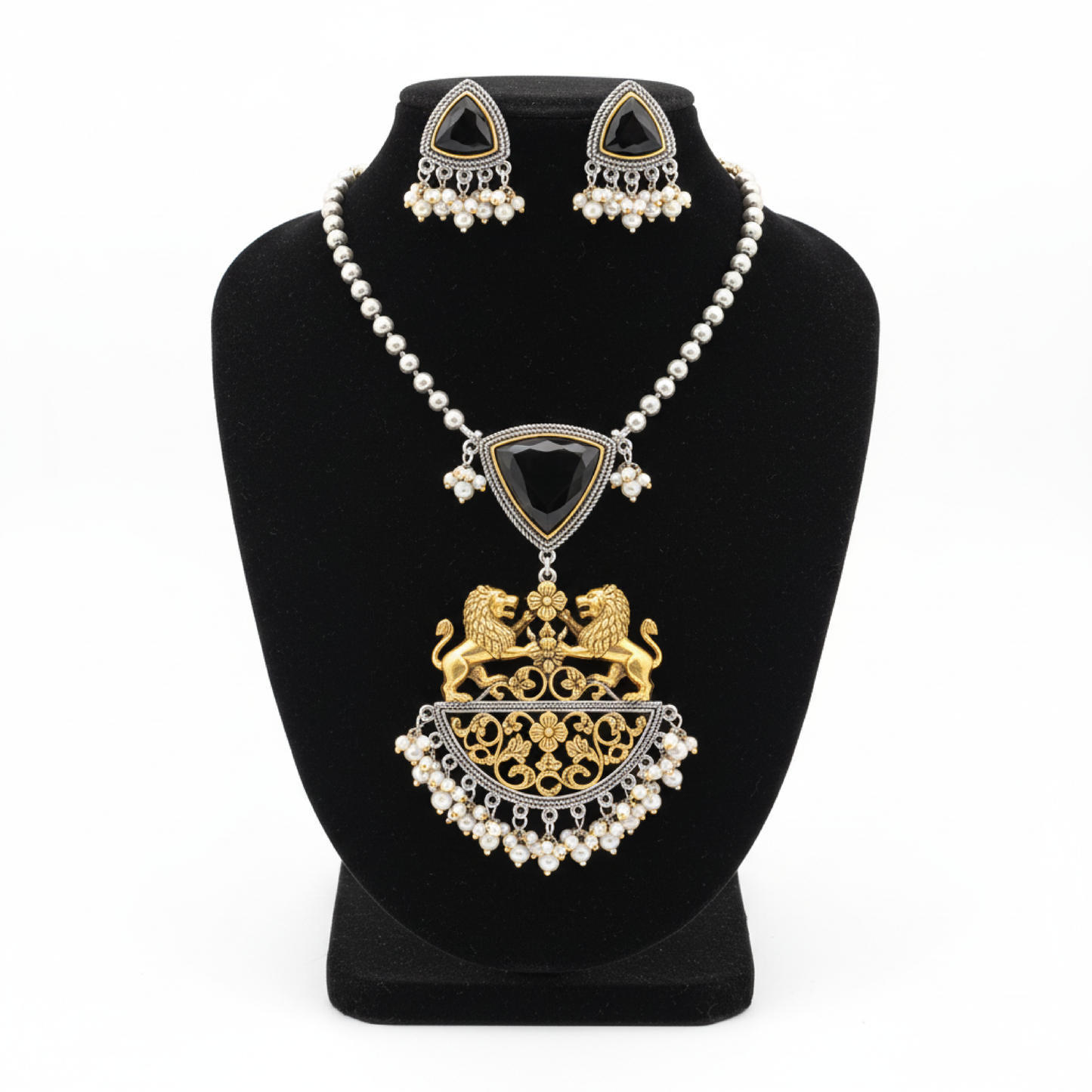 Royal black stone necklace set with golden lion motifs and pearl accents displayed on a black stand white