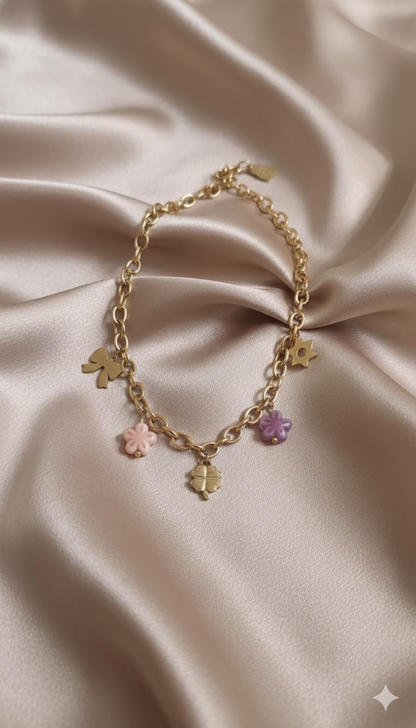 Gold-Plated Charm Necklace with Bow, Star, and Floral Pendants and Pink-Purple Bead Accents stand