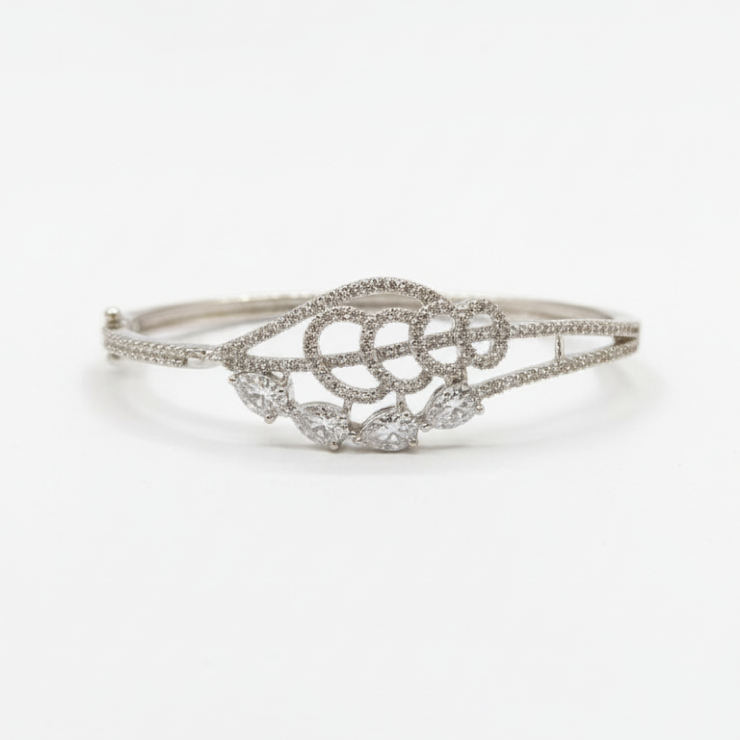 Elegant silver diamond bracelet with teardrop-shaped stones resting on soft beige satin fabric white