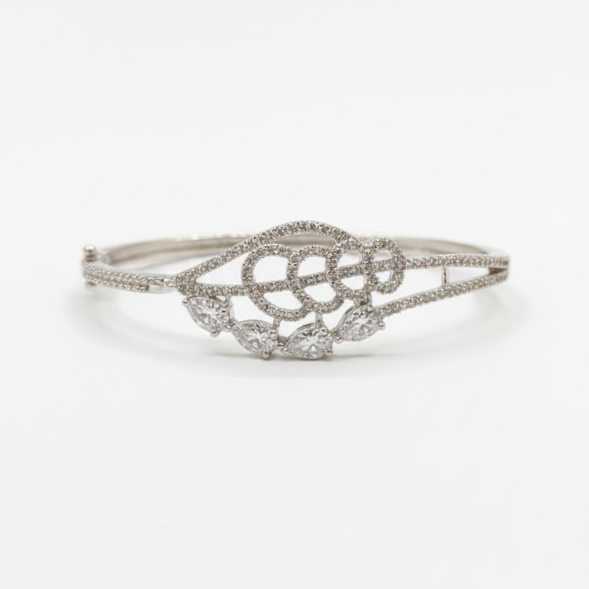 Elegant silver diamond bracelet with teardrop-shaped stones resting on soft beige satin fabric white