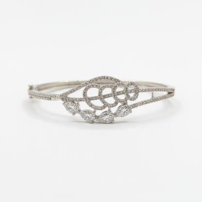 Elegant silver diamond bracelet with teardrop-shaped stones resting on soft beige satin fabric white