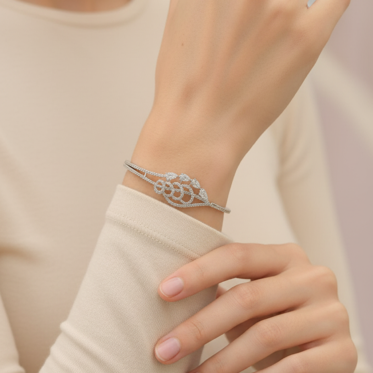 Elegant silver diamond bracelet with teardrop-shaped stones resting on soft beige satin fabric stand