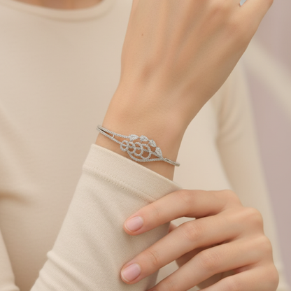 Elegant silver diamond bracelet with teardrop-shaped stones resting on soft beige satin fabric stand