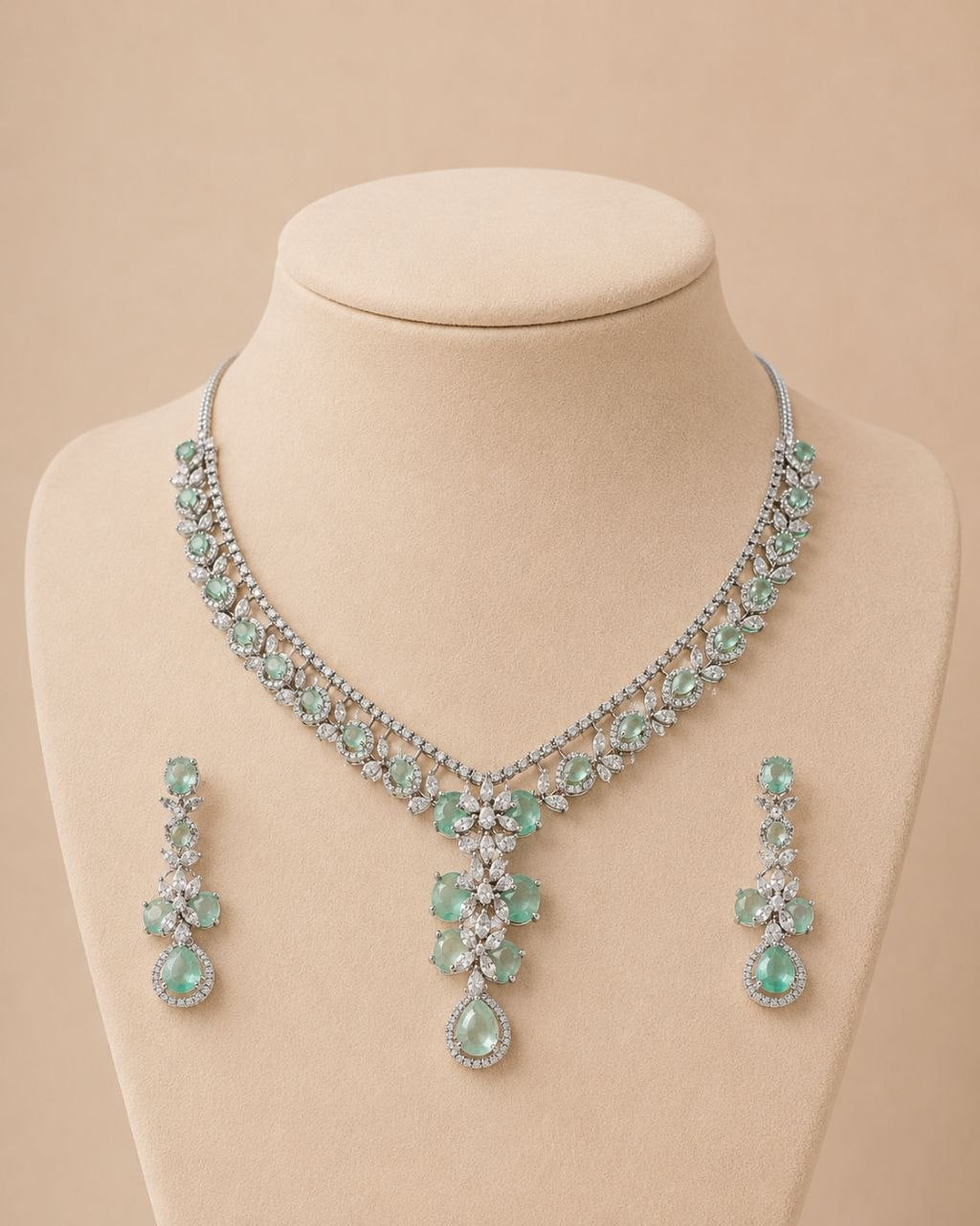 Mint green floral gemstone necklace with matching drop earrings set featuring clear stones on beige display bust 1