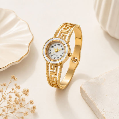 Gold women's bangle watch with intricate Greek key pattern on the band and luxurious mother-of-pearl dial featuring gold hands and markers 3