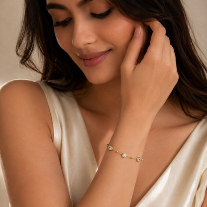 Delicate 18K gold plated chain bracelet with three round clear cubic zirconia stones and small gold beads on white background 2