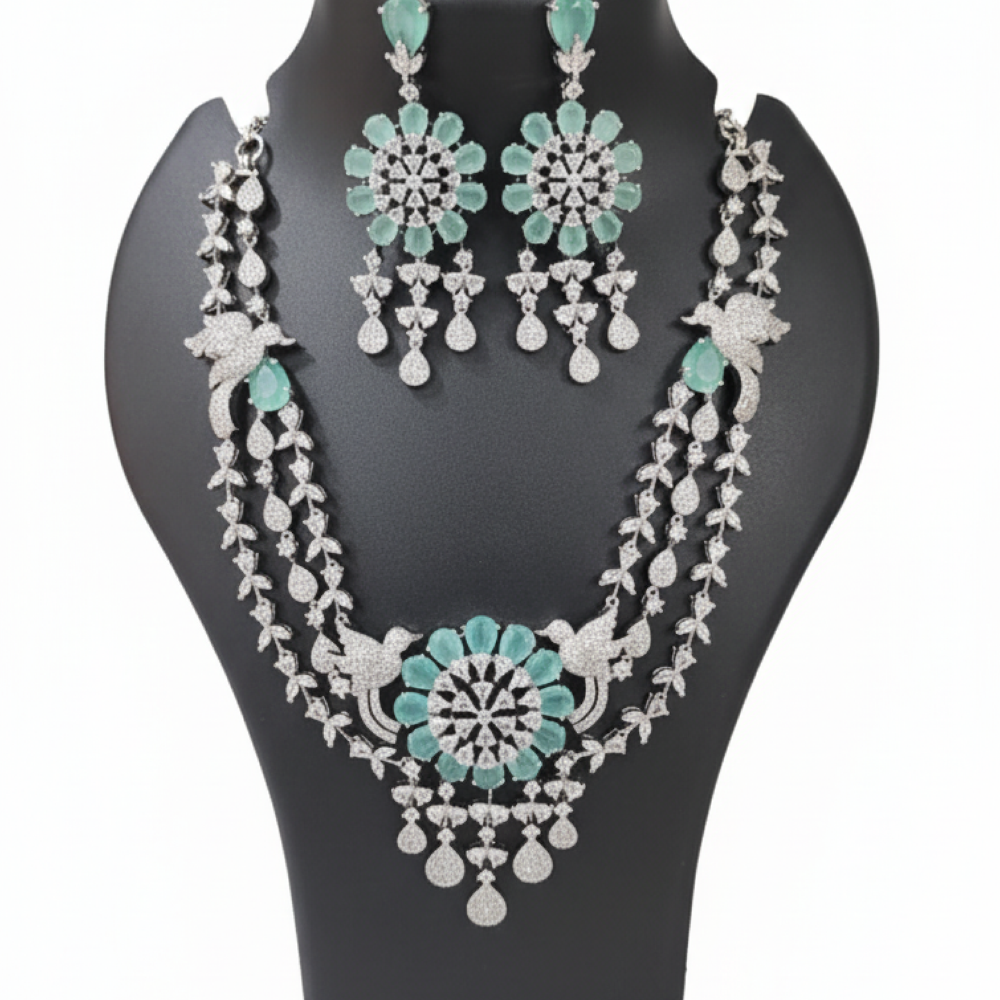 Aqua green double-layered necklace set with matching earrings featuring floral design and diamond detailing on black display white
