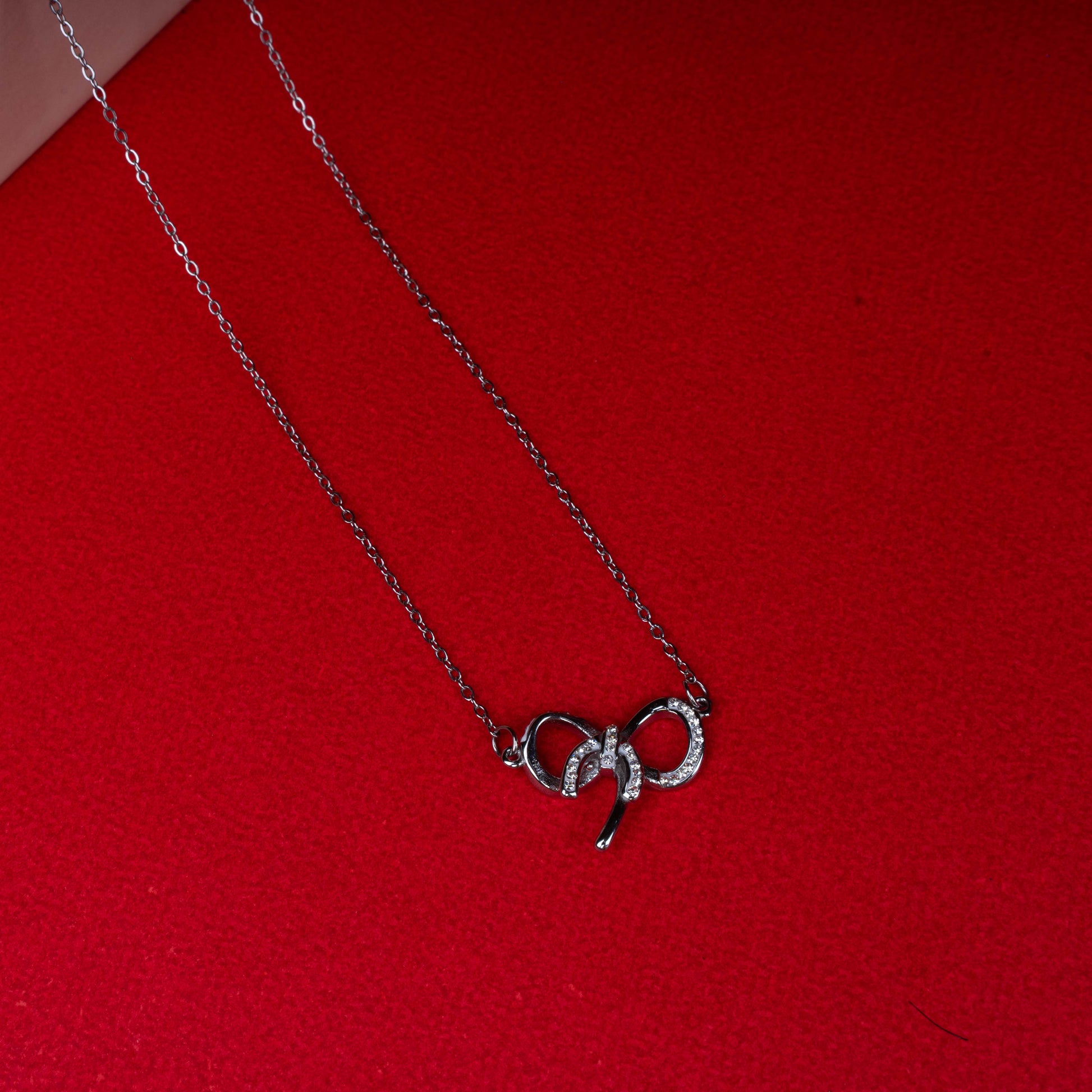 Silver bow pendant necklace with sparkling stone detailing second view - Revaaj