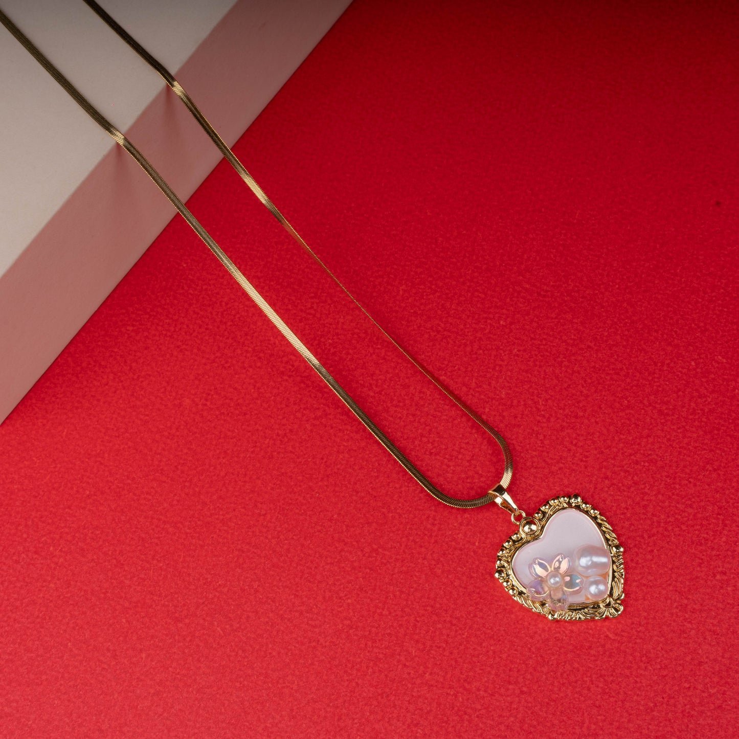 Gold necklace with textured chain and pink enamel pendant featuring a gold butterfly - Revaaj