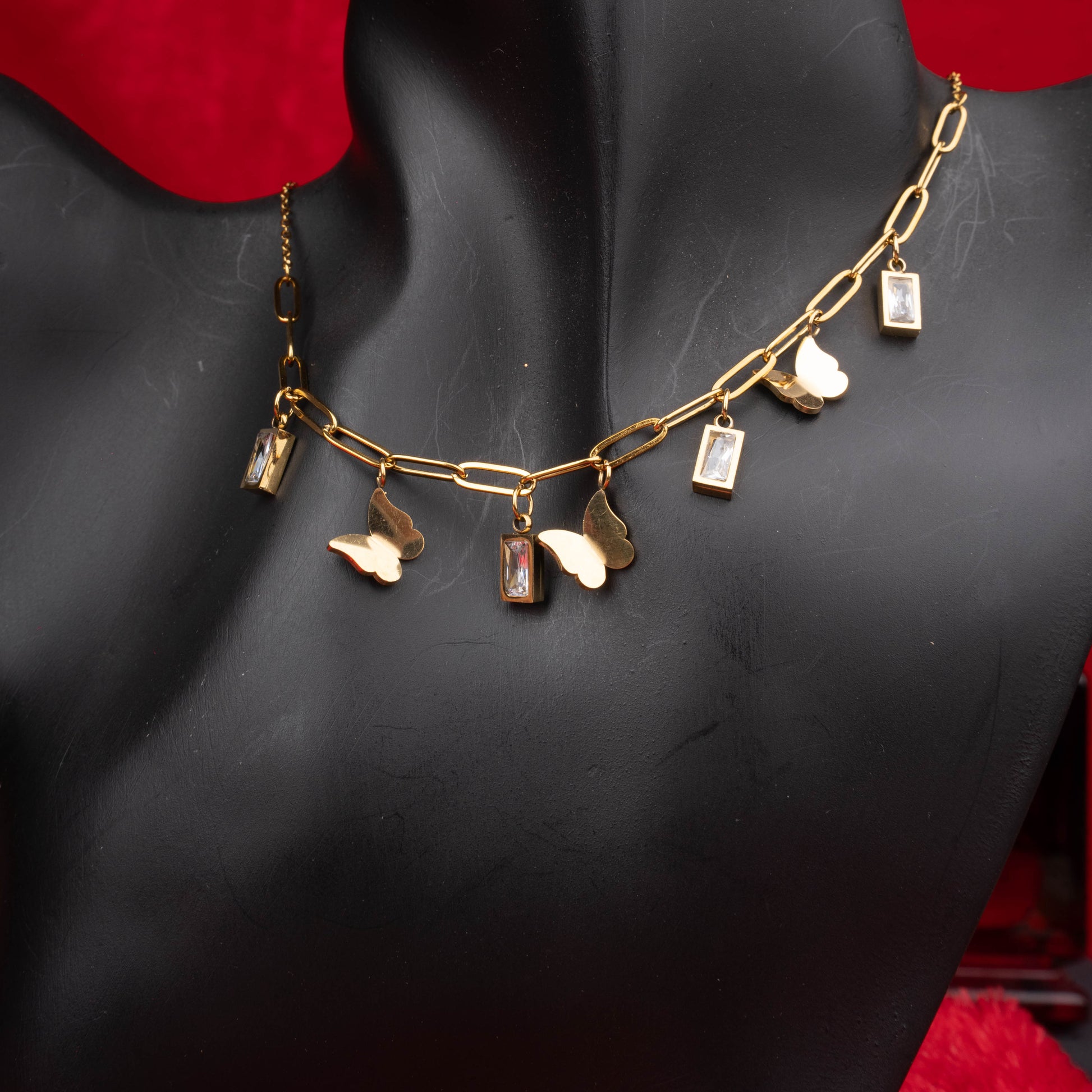 Gold link necklace with butterfly and rectangular crystal charms zoomed - Revaaj