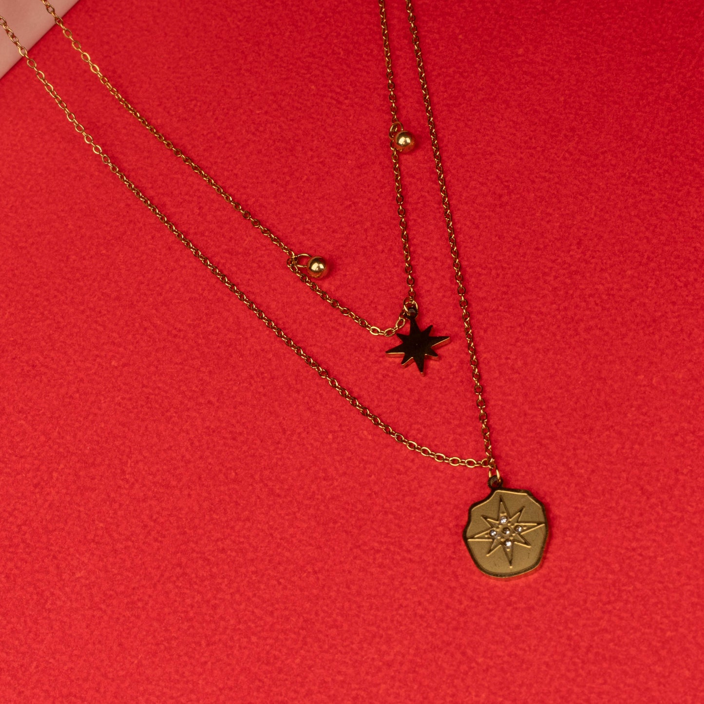 Gold layered necklace with star and compass pendants full image- Revaaj