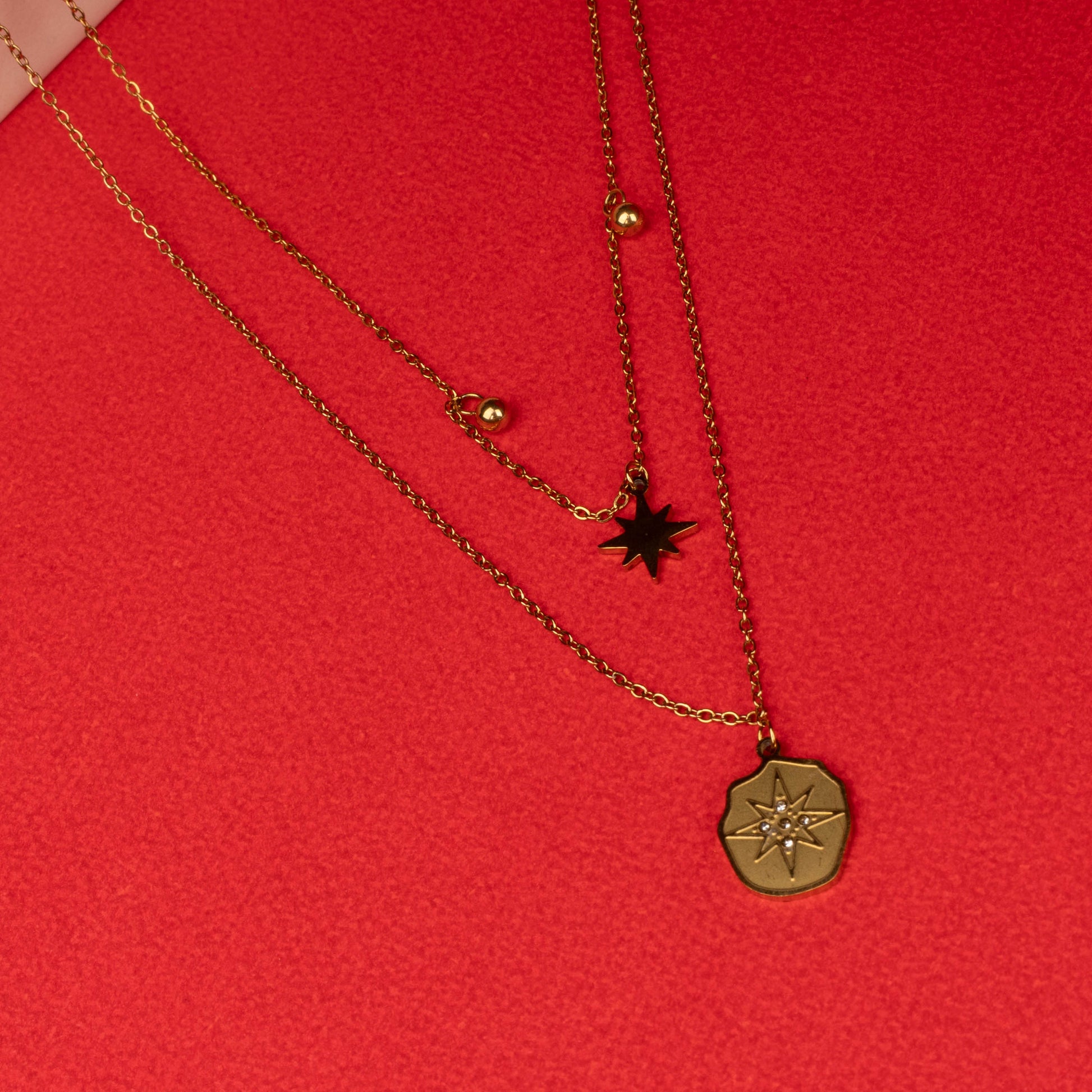 Gold layered necklace with star and compass pendants full image- Revaaj
