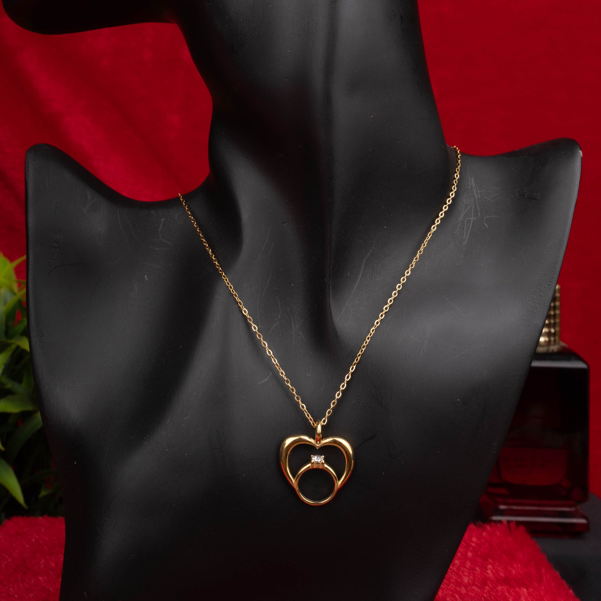 Gold heart pendant necklace with intertwined ring charm floored image - Revaaj