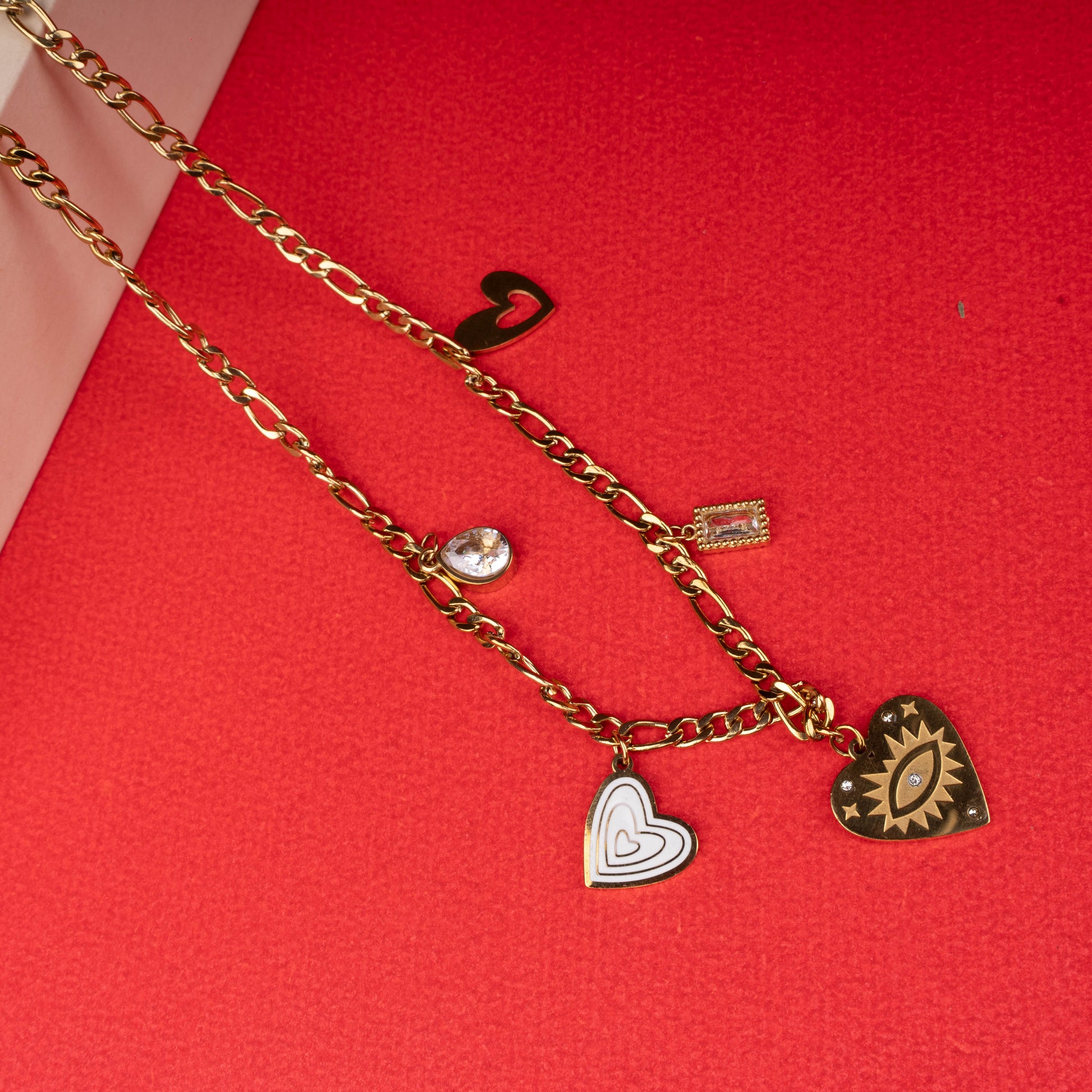 Gold charm necklace with enamel hearts, crystal, and sunburst eye charm - Revaaj