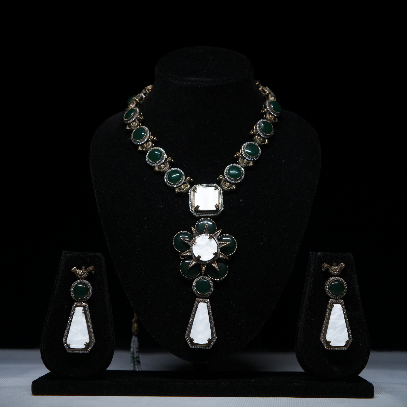 Revaaj Green and White Kundan Necklace Set displayed on a black stand, showcasing the necklace and matching earrings.