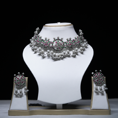 Revaaj Kundan Choker Necklace Set with matching earrings displayed on a white mannequin.  The necklace features pink and green gemstones and pearls.