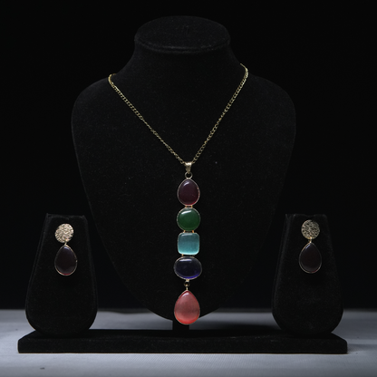 Revaaj multicolored stone necklace and earring set displayed on a black jewelry stand.
