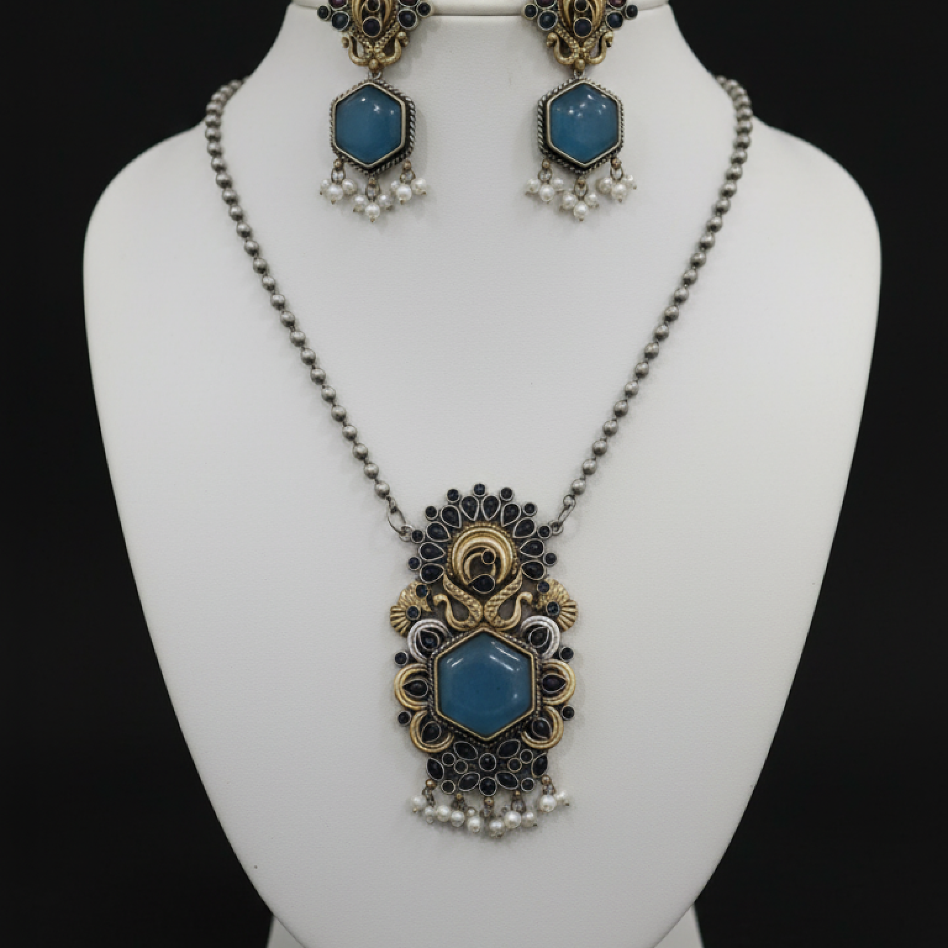 Antique peacock necklace set with blue gemstone pendant, pearl drops, and matching earrings in gold finish Stand
