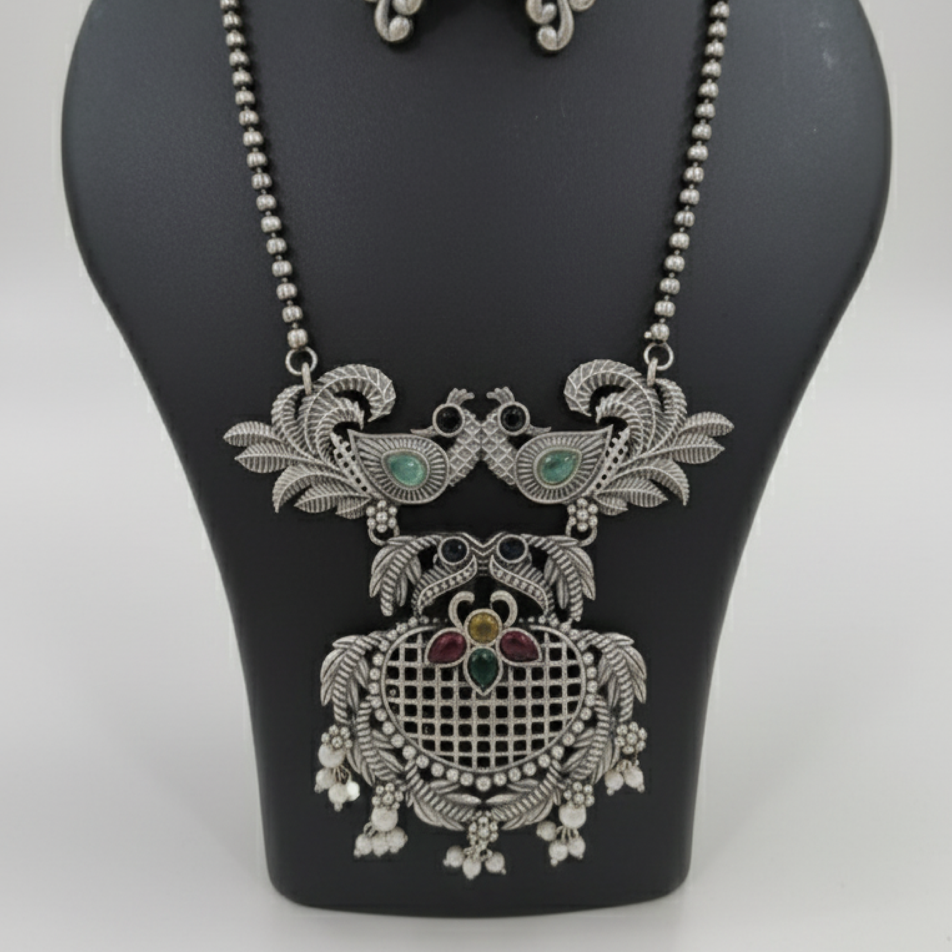 Oxidized silver necklace set with peacock design and multicolor stones by Revaaj Jewellery